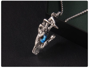 Detailed close-up of a gothic skeleton hand claw clutching a blue Turkish evil eye pendant