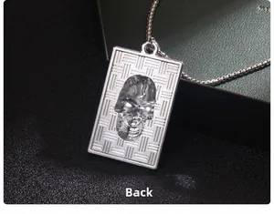 Macro shot of silver stainless steel skull pendant with textured gothic industrial pattern