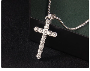 Close-up of sparkling silver cross pendant with crystals on a metal box chain