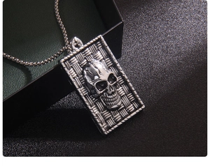 Detail shot of vintage stainless steel skull pendant on a black jewelry gift box