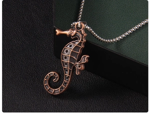 Macro detail of antique bronze seahorse pendant with textured sea life design on bead chain