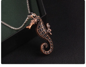 Macro detail of a vintage seahorse pendant with bronze finish and silver chain