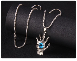 Macro shot of silver gothic hand pendant with a blue evil eye stone on black leather