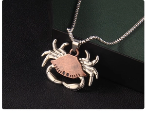 Detailed close-up of the vintage crab pendant with red copper shell on silver box chain