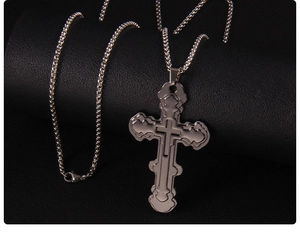 Detailed close-up of a silver triple-layered stainless steel cross pendant on a box chain