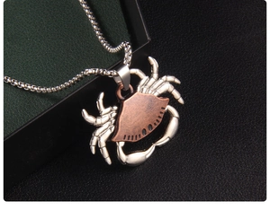 Macro detail of punk style crab pendant with bicolor silver and copper metal finish
