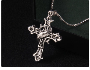 Gros plan macro d'un pendentif croix gothique avec ruban gravé sur cuir noir texturé
