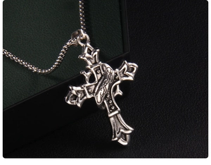 Gros plan du pendentif croix gothique argentée avec gravure Forever et chaîne vintage