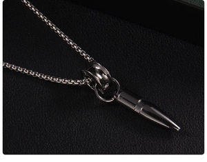 Macro shot of stainless steel black bullet pendant and box chain for hip hop style