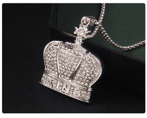Macro shot of silver hip-hop crown pendant with sparkling crystals and KING lettering