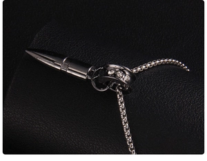 Close-up of black bullet pendant necklace with sparkling zircons on a leather texture