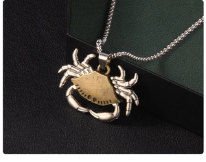 Macro shot of vintage silver crab pendant with intricate punk textures and ball chain