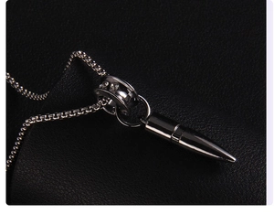 Macro view of silver bullet pendant with crystal ring and durable box chain detail