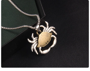 Macro detail of bicolored crab pendant showing textured shell and industrial design style