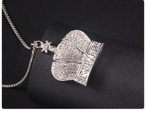 Detailed macro view of silver crown pendant with KING engraving and inlaid crystals