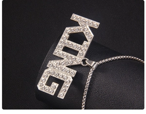 Macro detail of silver stainless steel KING pendant with white cubic zirconia pavé