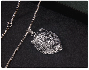 Gros plan d'un pendentif lion rugissant avec chaîne maille vénitienne sur fond noir