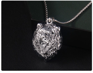Gros plan d'un pendentif tête d'ours en argent avec détails métalliques et chaîne à billes