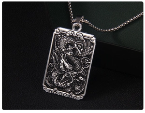 Macro view of Chinese dragon relief on rectangular stainless steel pendant necklace