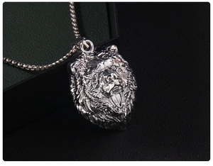 Vue latérale macro du pendentif tête de lion rugissant en acier poli sur fond en cuir
