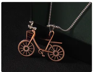 Macro detail of a vintage bicycle pendant necklace with antique bronze finish and box chain