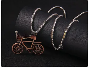 Detail of vintage bicycle pendant with copper finish on silver tone chain link