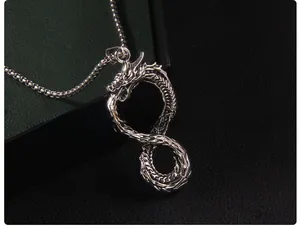 Macro di un ciondolo a forma di drago in argento vintage con scaglie e catena a sfere