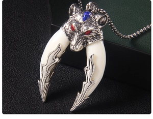 Macro detail of vintage wolf head pendant with red eyes and blue stone on a bead chain