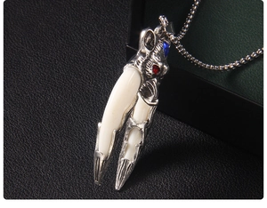 Close-up of punk style wolf tooth pendant with red gemstone eyes and silver metal carving