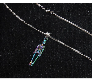 Macro detail of punk rainbow skull pendant and silver box chain on dark background