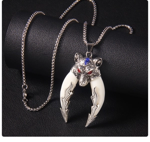 Macro detail of tribal wolf pendant with red gemstone eyes and blue crystal accent