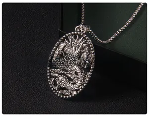 Dettaglio ravvicinato del ciondolo drago vintage in argento con catena a scatola