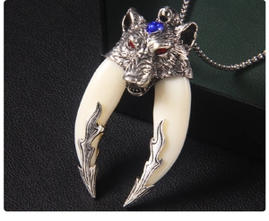 Macro shot of punk wolf head pendant with blue gemstone and dual white acrylic tusks