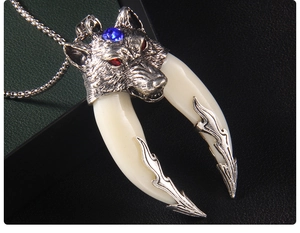 Macro view of vintage wolf head pendant with red eye gems and dual acrylic fangs