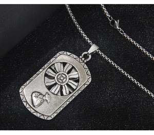 Detail of vintage silver rotating pendant with coin pattern and lucky money bag design