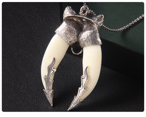 Close-up of wolf head pendant with ivory-style horns and vintage silver ball chain