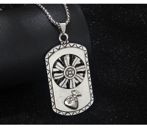 Macro detail of silver rectangular pendant with relief money bag and yen symbol