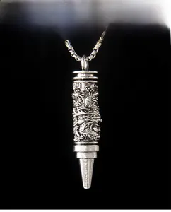 Vue détaillée du pendentif cylindrique en argent vintage avec motif de dragon en relief