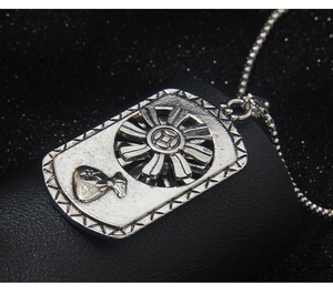 Macro shot of rotating vintage rectangular money bag pendant with gear wheel detail