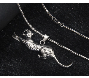 Macro detail of a leaping tiger pendant made of polished steel with black stripe engraving