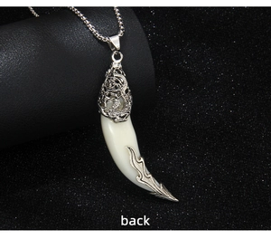 Vue arrière détaillée du pendentif dent de loup avec relief dragon et accents de flammes