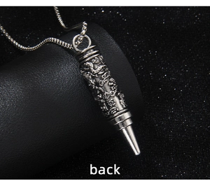 Vue macro d'un pendentif balle en argent avec relief de dragon et patine vintage
