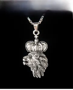 Detailed close-up of a silver lion head pendant with a crown on a dark background