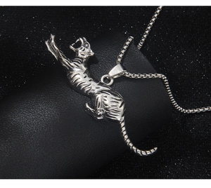 Close-up of a silver leopard pendant on a box chain featuring detailed etching and metal texture