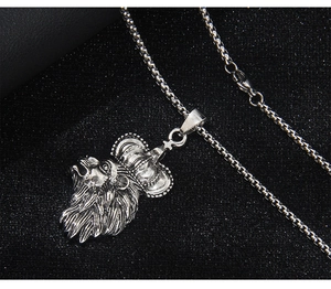 Close-up of vintage silver lion head pendant with crown detail on a steel box chain