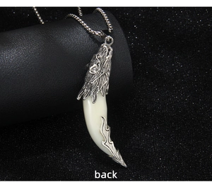 Vue arrière macro du pendentif tête de loup vintage avec croc et texture argentée