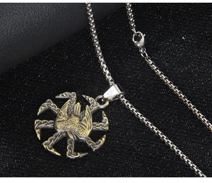 Détail macro du pendentif slave Kolovrat avec oiseau doré et finition argentée