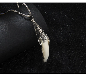 Vue macro d'un pendentif dent de loup rétro avec sertissage en métal argenté vieilli