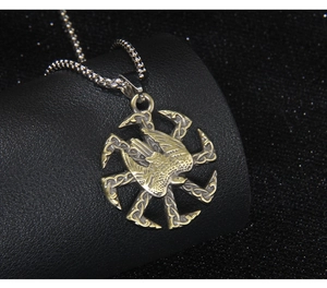 Détail macro du pendentif slave Kolovrat bicolore avec totem d'aigle sur support cuir