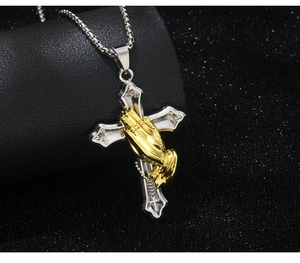 Close-up of stainless steel cross pendant with gold praying hands on box chain